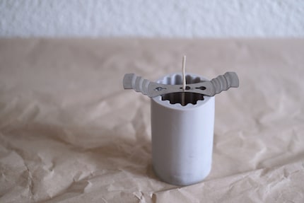 A metal holder helps hold the wick in place.