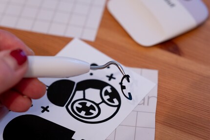 I use a hook-shaped tool to remove the parts I don’t need from the design.