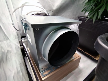 À l’arrière gauche de la tente, un préfiltre est placé sur une boîte de rangement retournée. Ensuite, on voit un tuyau d’aération de 160 mm, un ventilateur tubulaire et un filtre à charbon actif. Cela permet de gagner de la place à l’intérieur de la tente.