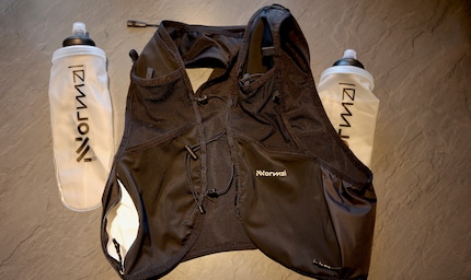 The running waistcoat with the two flasks has a white-coated waterproof back pocket and a small whistle, top left in the picture.
