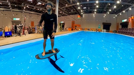 Ensis-Teamfahrer Michi Näf zeigt im Pool der Bootsmesse, wie ein Board mit Hydrofoil und Muskelkraft abhebt.