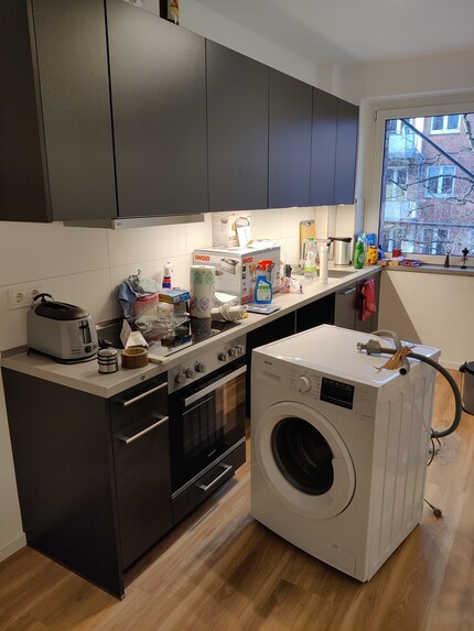 La vue de la cuisine : le lave-linge est au milieu de la pièce et doit encore être placé dans le coin cuisine.