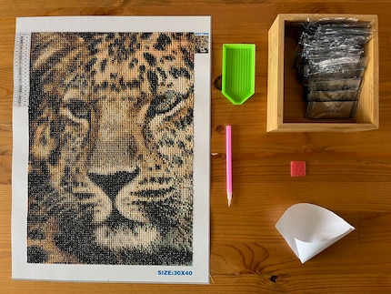 Le kit contient tout ce dont j’ai besoin pour broder. Je me suis aussi bricolé un entonnoir en papier pour ranger plus facilement les diamants dans les sachets.