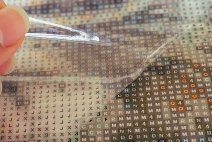 La toile est recouverte d’une couche adhésive sur laquelle on colle les diamants.
