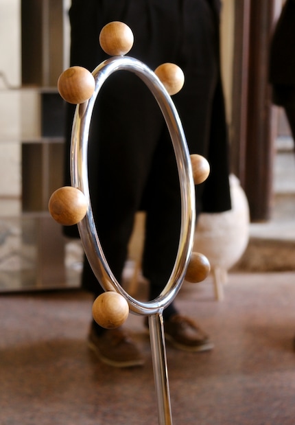 Lo schienale è decorato da una serie di sfere di legno, come una collana di perle.