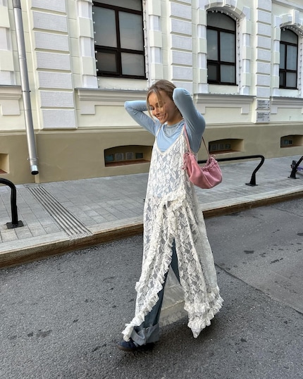 Lace maxi dress over baggy jeans – a textbook style clash.