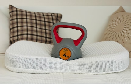 Mein Kettlebell dient als Kopf-Simulation. Die vier Kilogramm Gewicht drücken das Kissen deutlich sichtbar zusammen. An der Seite hebt das Kissen dadurch sogar leicht ab.
