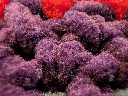 Photo macro de mon ouvrage au crochet : chaque poil de la laine est reconnaissable, même si le bord de la photo est flou.