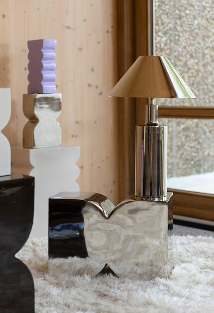 Hier werden spiegelnde, kühle Designs mit Fellen und Holzmöbeln aufgewärmt.