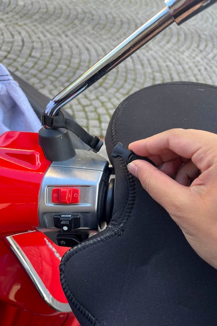 Damit er während der Fahrt nicht davon fliegt, wird er mit einem Klickverschluss am Seitenspiegel befestigt.