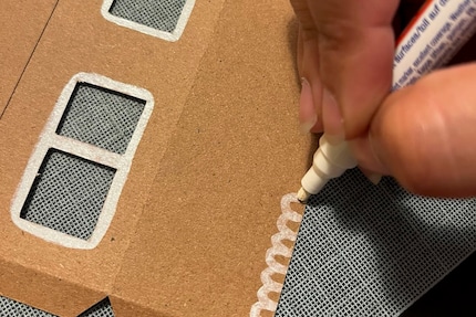 Disegno il tetto e abbellisco le pareti della casa con un pennarello bianco.