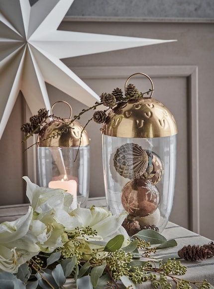 Ein Windlicht kombiniert mit Christbaumkugeln verleiht deinem Raum eine persönliche Note.