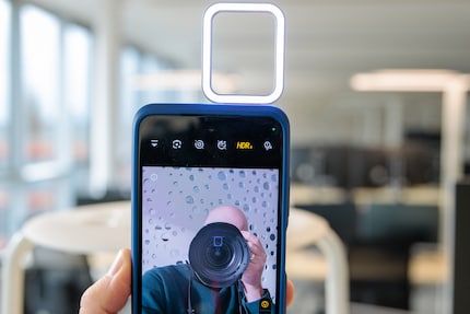 La luce anulare si riflette negli occhiali e nelle lenti della fotocamera.