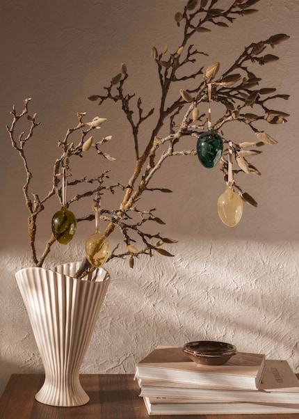 Un accroche-regard : l’arbuste de Pâques dans un vase plissé allie élégance et légèreté printanière.