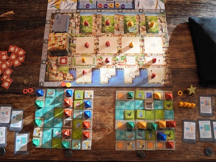 Sur le plateau de jeu, je rassemble les matériaux avec lesquels je construis mes quartiers (deux terrains de construction sont visibles ci-dessous).