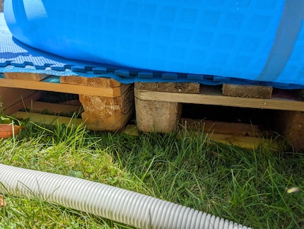 Mit einem Brett können die gröbsten Unebenheiten korrigiert werden. Am besten, bevor das Wasser drin ist.