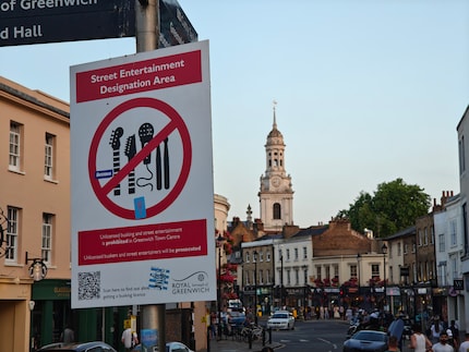 Mit der Telekamera lenke die Aufmerksamkeit auf das Schild und schmücke den Hintergrund mit der St. Alfege Church.