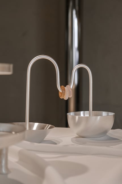 Le due ciotole del set «Aperitivo» sono collegate da un tubo metallico ornato da tre scorrevoli anellini di quarzo.