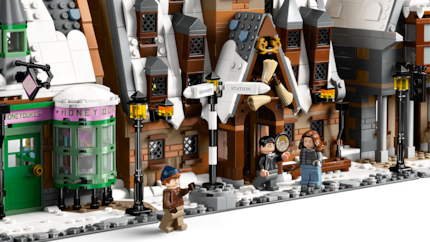 Vor dem Hog’s Head sitzen Harry, Hermine und Ron mitten im verschneiten Hogsmeade.