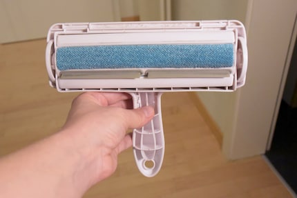 Die blaue, elektrostatische Oberfläche absorbiert Haare und streift sie beim Rollen im Auffangbehälter ab.